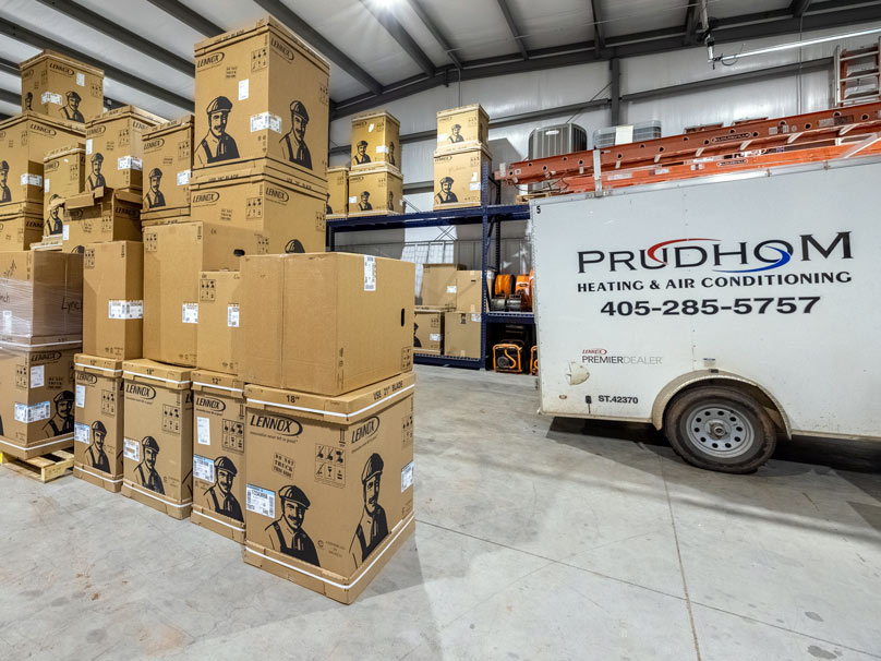 Prudhom van next to a stack of Lennox ACs.